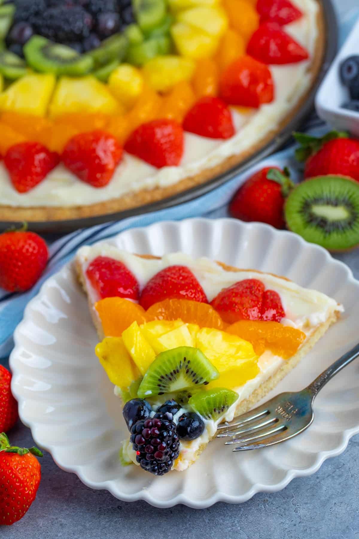 all types of fruit laid in rainbow order on a triangle piece of dough.