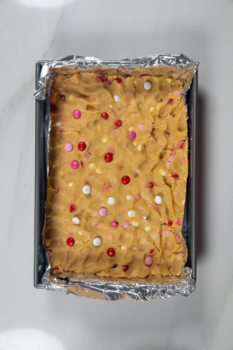 raw blondies before baking in a grey pan with foil.
