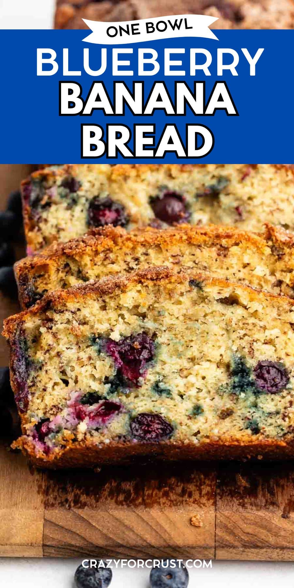 Sliced Blueberry Banana Bread on a wooden board displays its moist texture and visible blueberries. A blue text banner above reads One Bowl Blueberry Banana Bread. Website crazyforcrust.com is at the bottom.