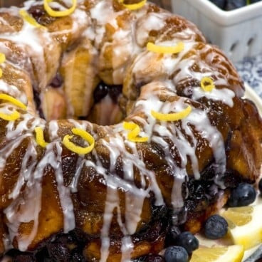 monkey bread covered in glaze and blueberries and lemon slices.