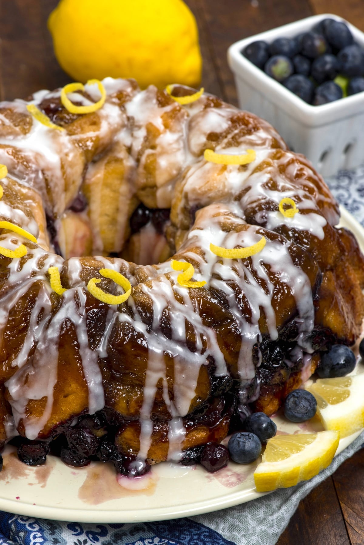 monkey bread covered in glaze and blueberries and lemon slices.