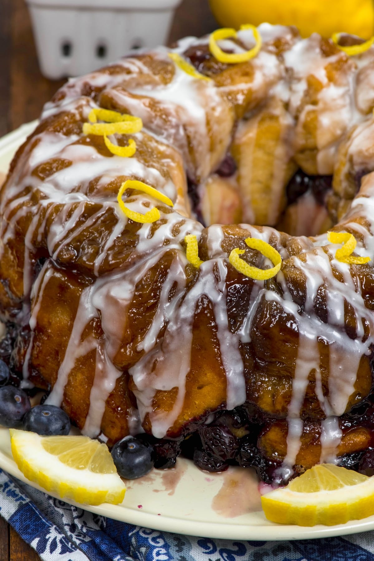 monkey bread covered in glaze and blueberries and lemon slices.