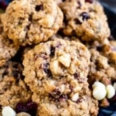 stacked cookies with white chocolate and cranberries baked in on a blue plate.