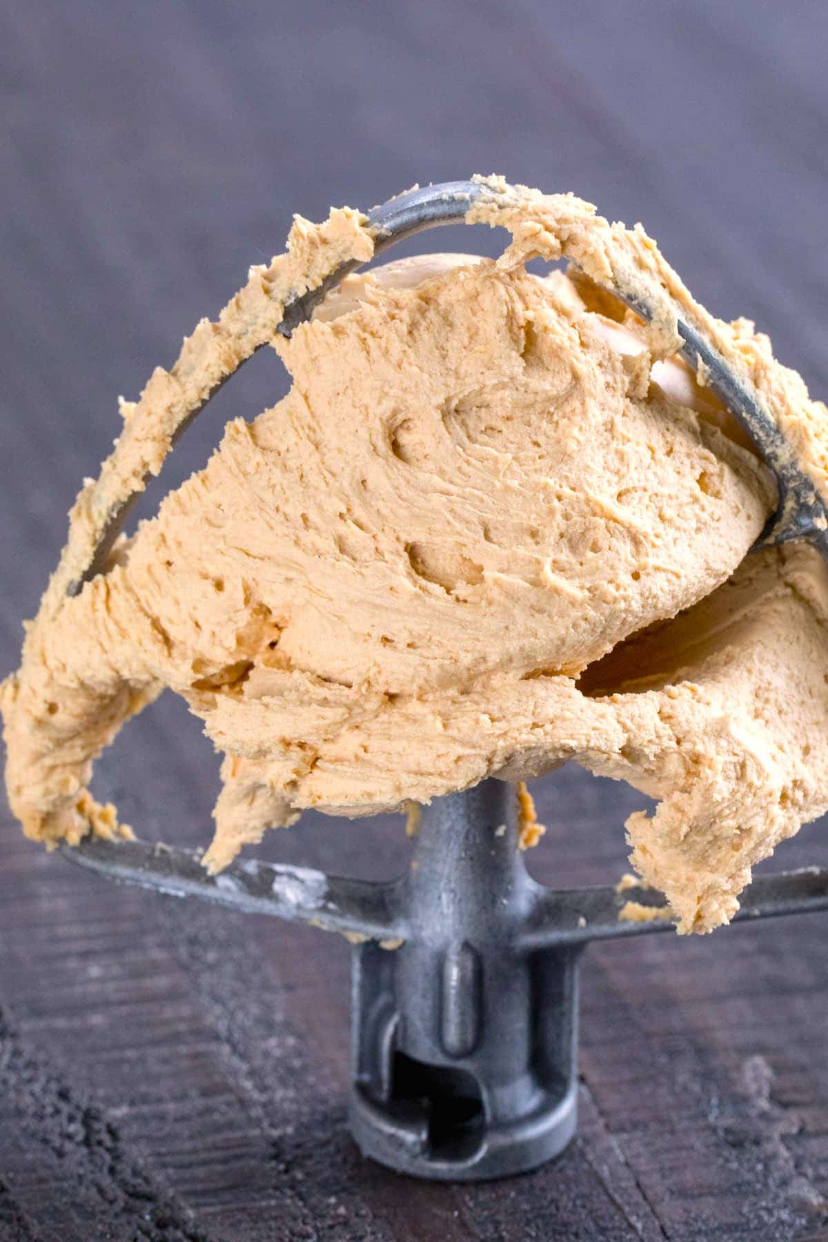 peanut butter frosting on a grey metal mixer.
