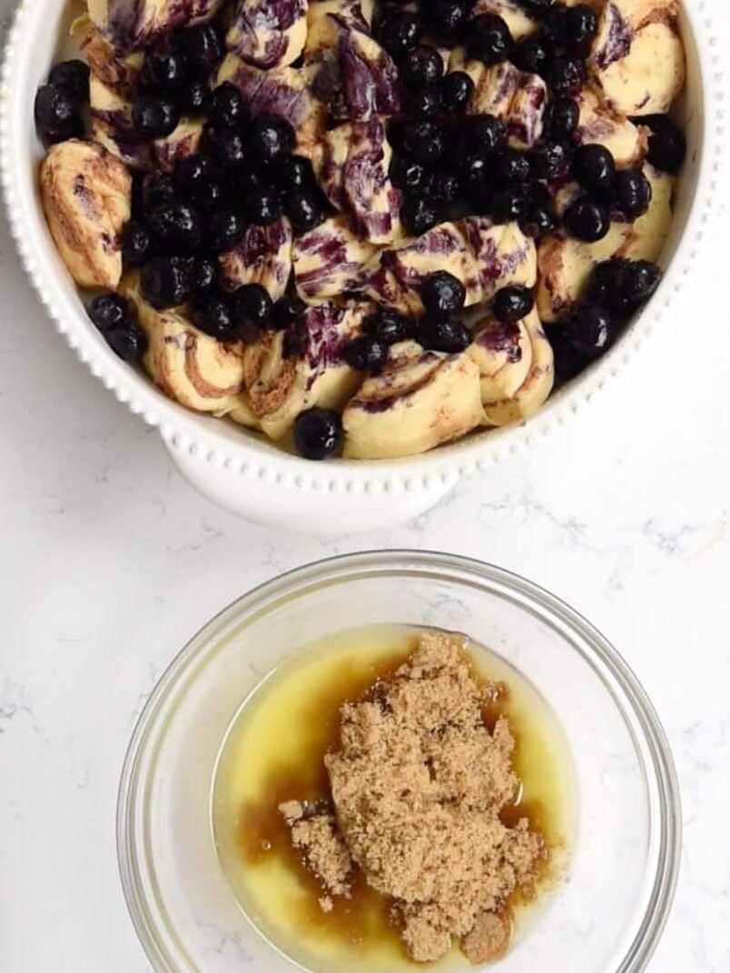 process shot of blueberry cinnamon roll bake being made.