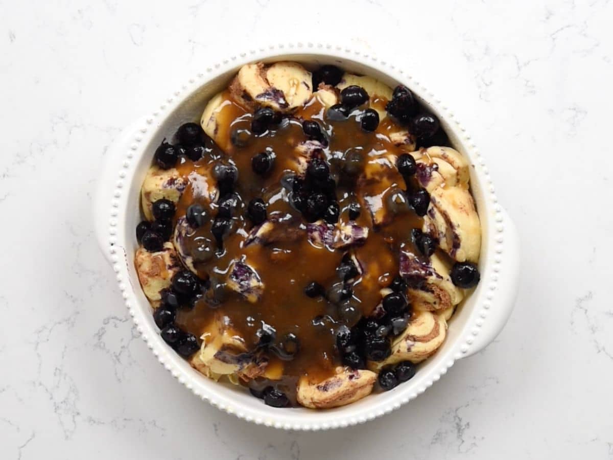 process shot of blueberry cinnamon roll bake being made.