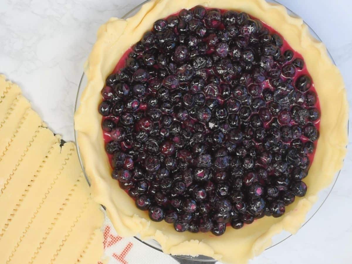 process shot of blueberry lattice pie.