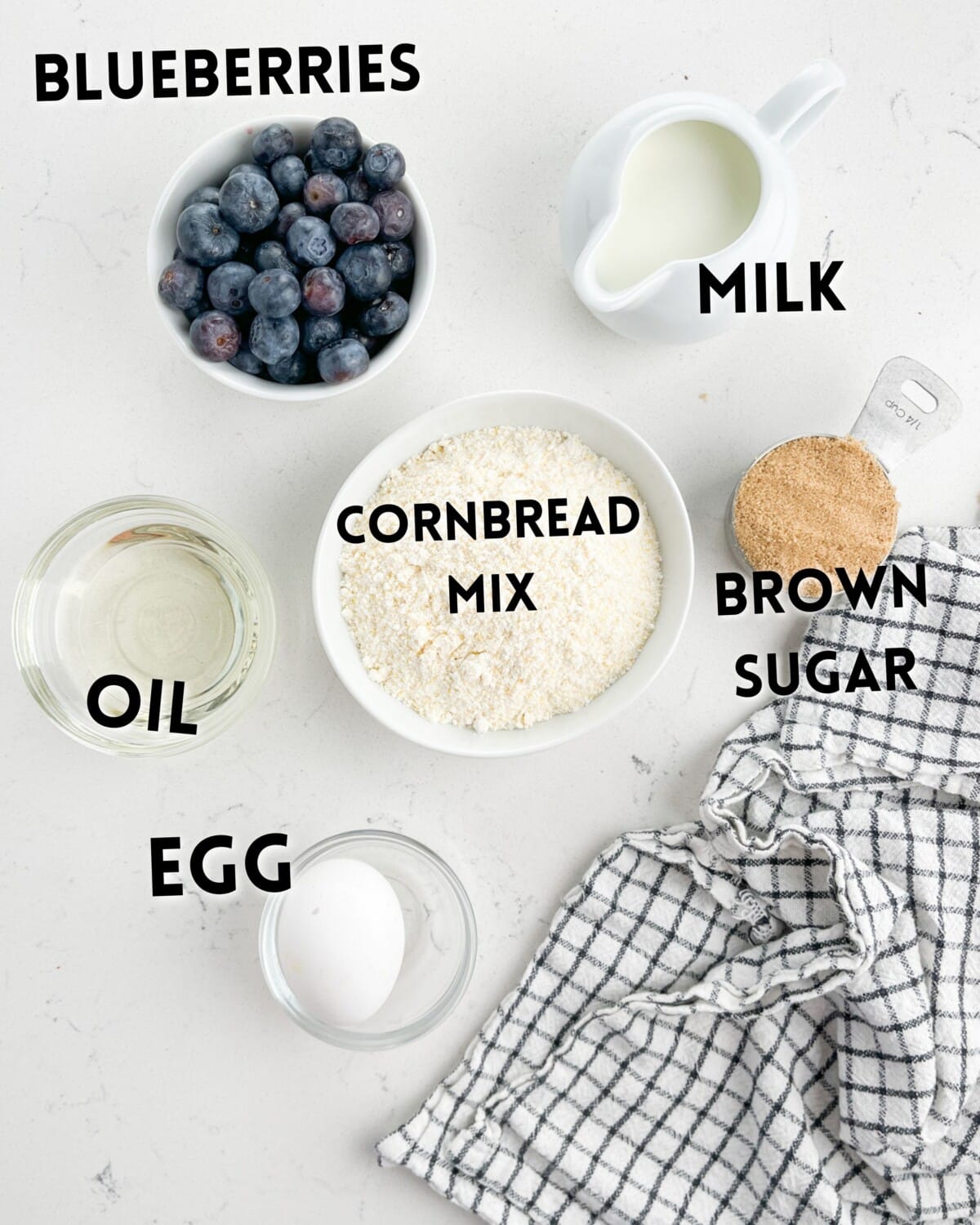 ingredients in blueberry oatmeal laid out on a white counter.