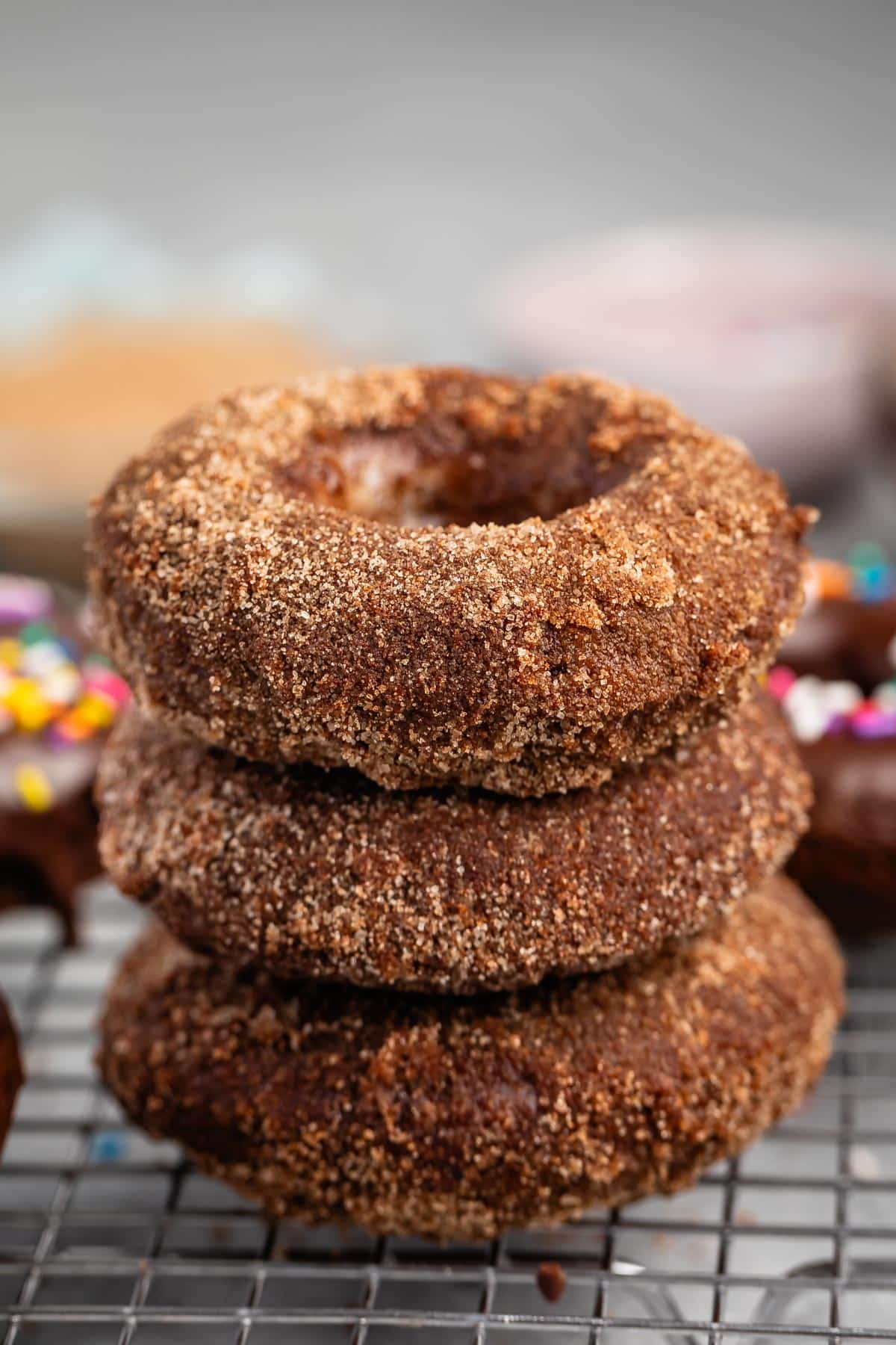 stacked chocolate donuts covered in sugar.