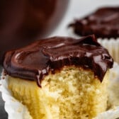 yellow cupcakes topped with chocolate sour cream frosting.