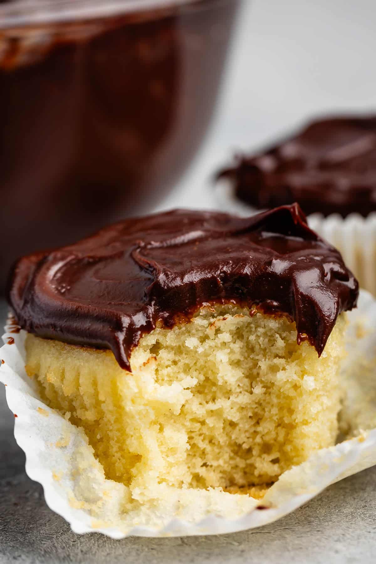 yellow cupcakes topped with chocolate sour cream frosting.