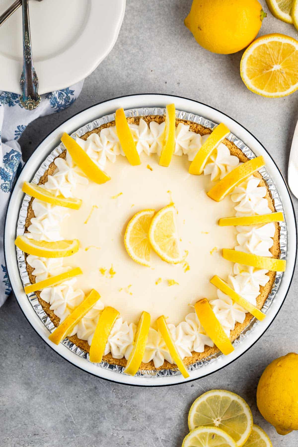 lemon pie in a tin with sliced lemons on top.