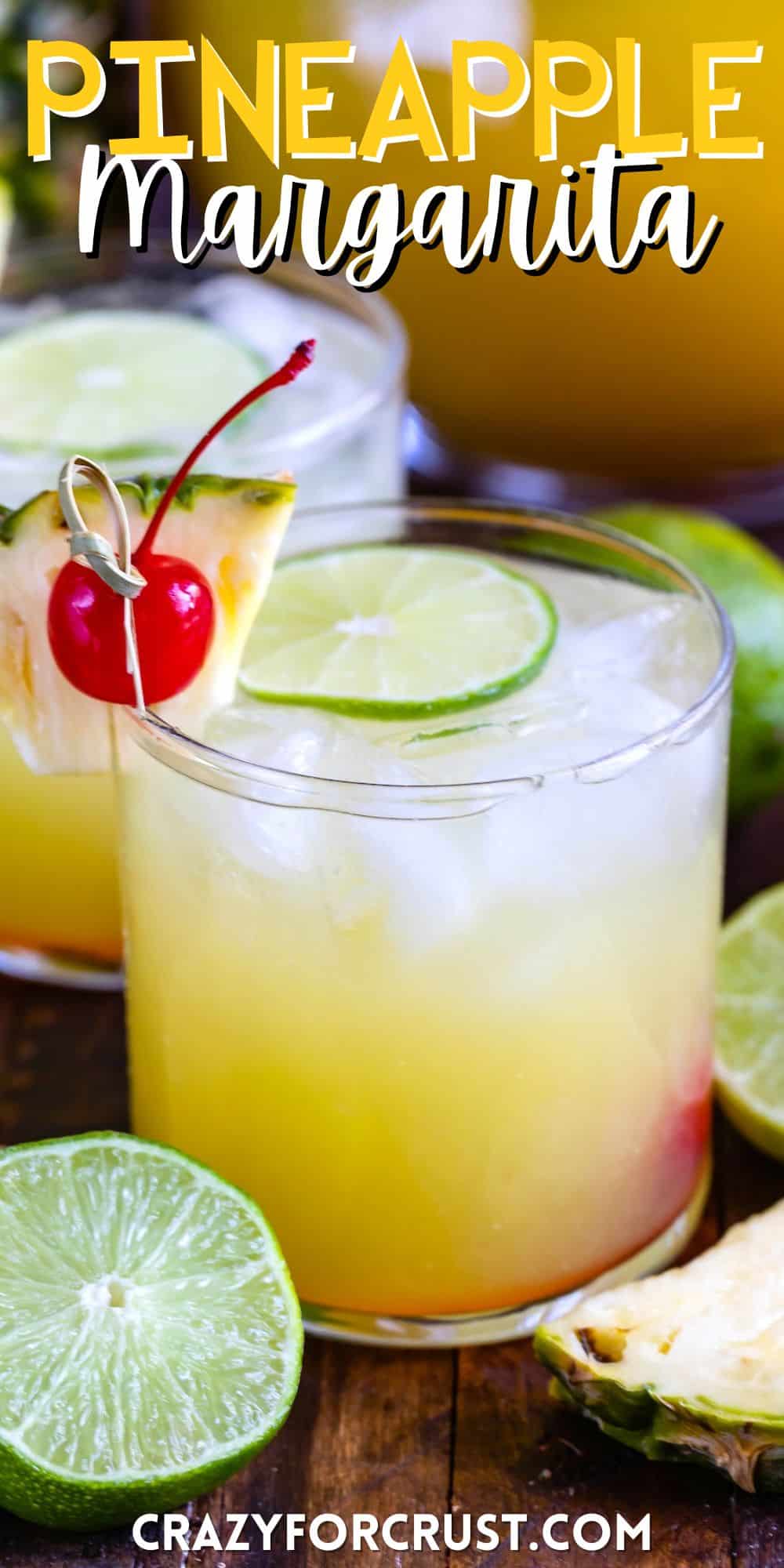 yellow drink in a short clear glass with cherries and pineapple slices and limes on the rim with words on the image.