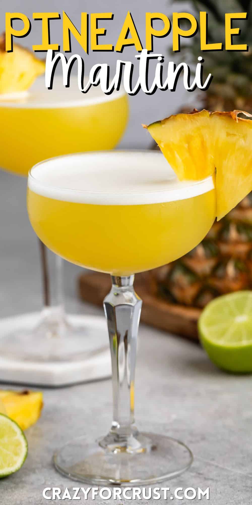 tall clear martini glass holding a yellow drink with a pineapple slice on the rim with words on the image.