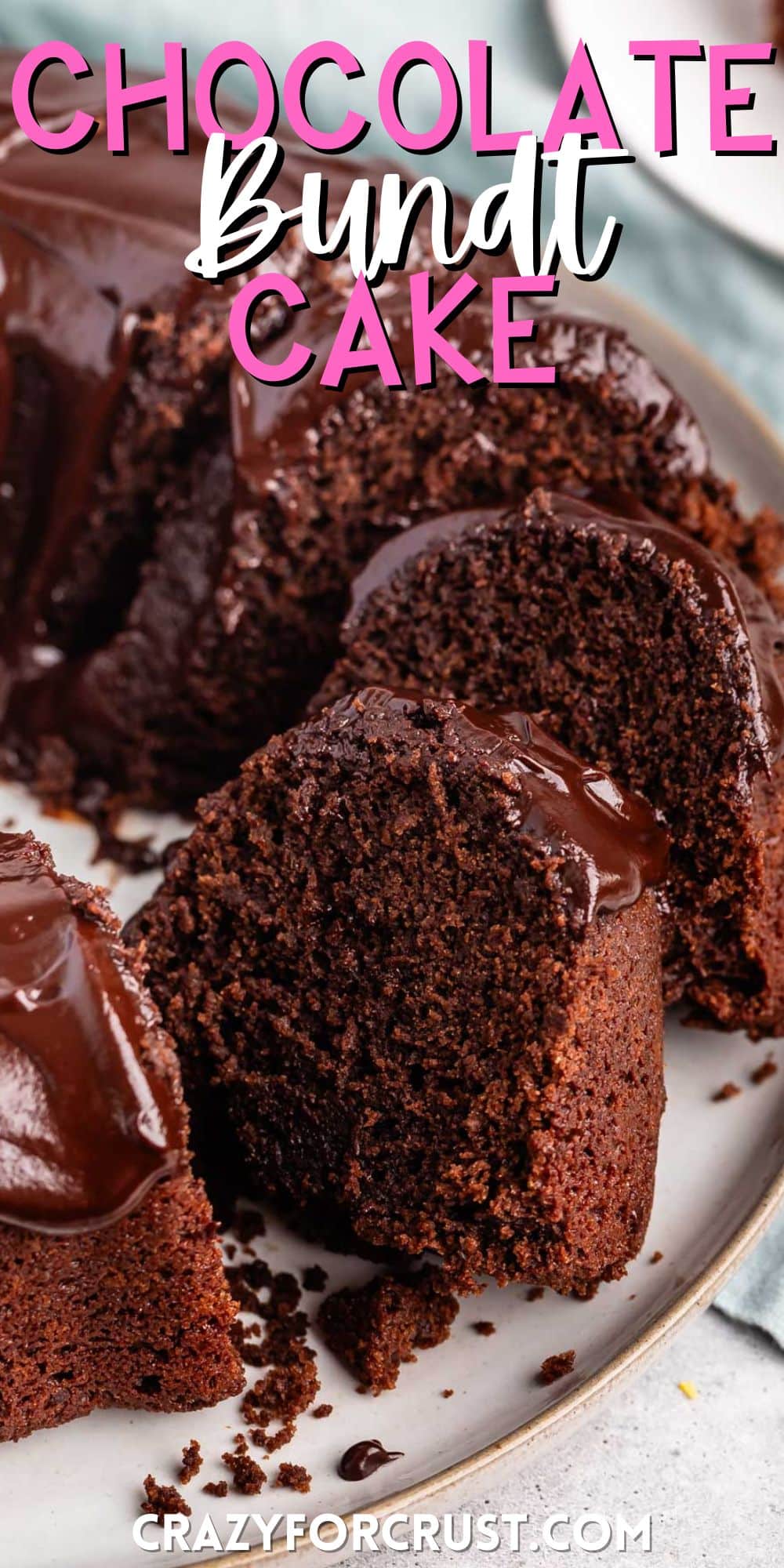 slice of chocolate cake on a white plate with a chocolate glaze on top with words on the image.