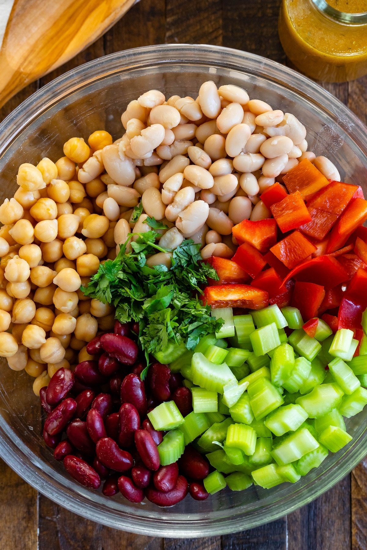 bean salad mixed with vegetables in a clear bowl.