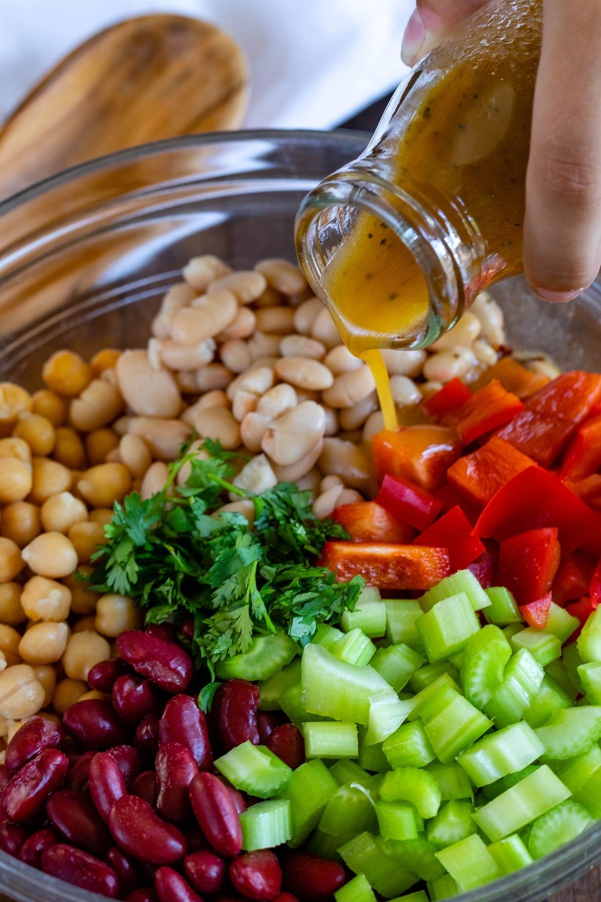 bean salad mixed with vegetables in a clear bowl.