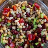 bean salad mixed with vegetables in a clear bowl.