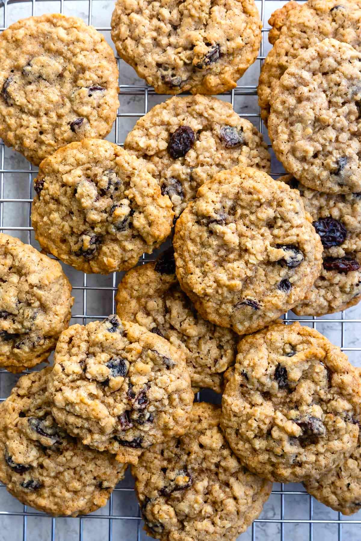 stacked oatmeal cookies with raisins on a drying rack.