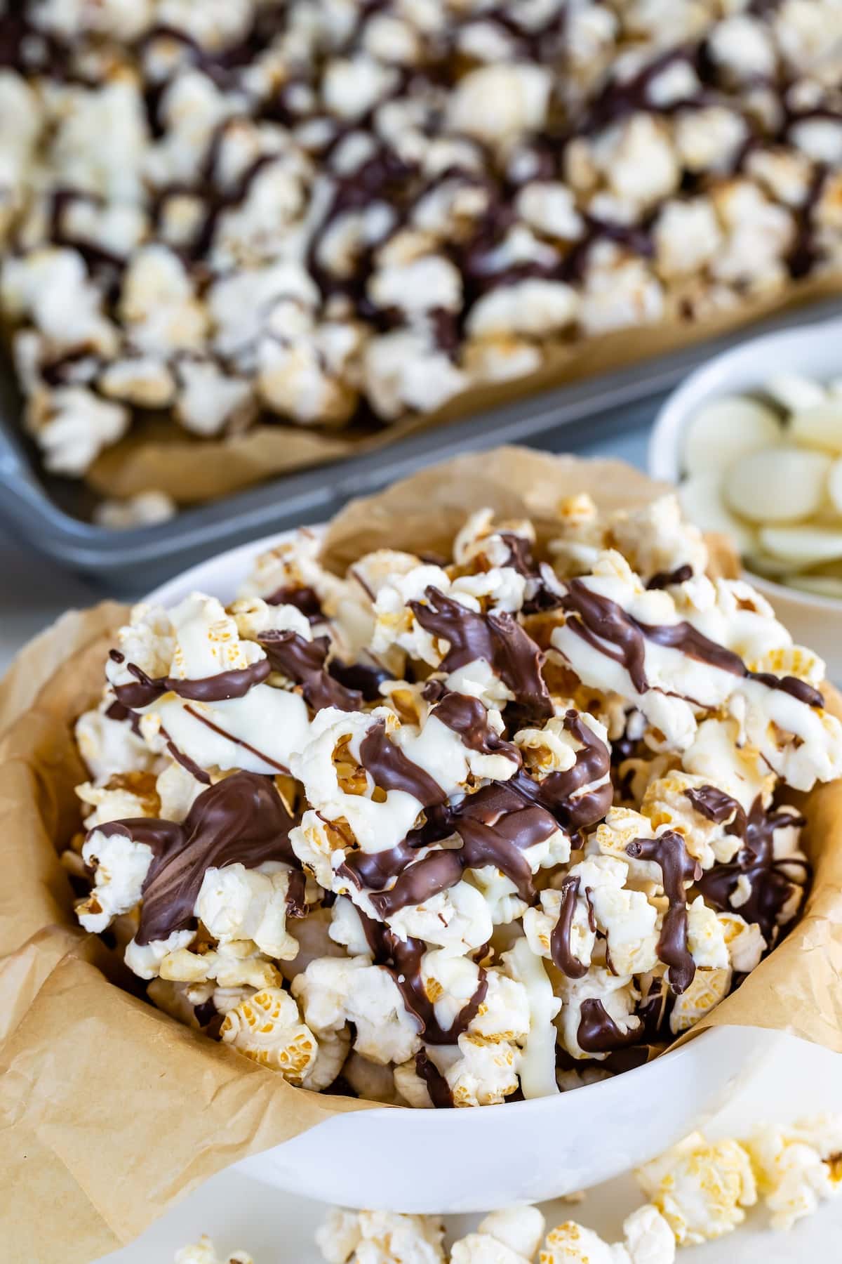 popcorn in a white bowl covered in chocolate drizzle.