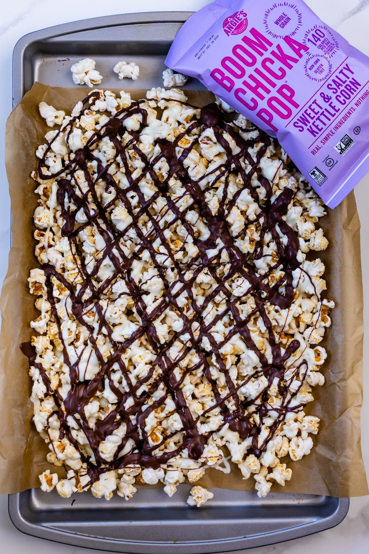 popcorn on a baking sheet covered in chocolate drizzle.