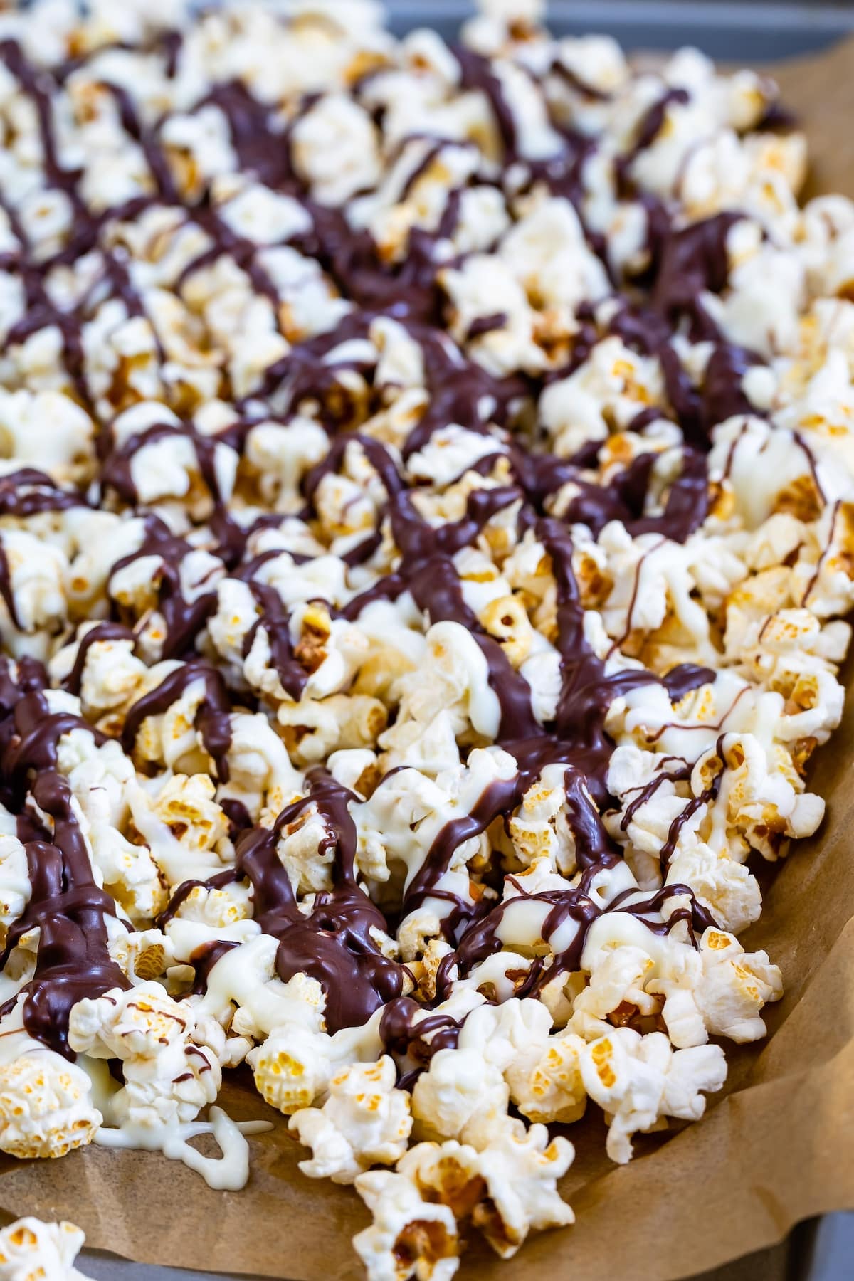 popcorn on a baking sheet covered in chocolate drizzle.