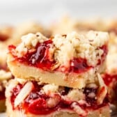 pie crust bars with red cherry pie filling and sliced almonds on top.