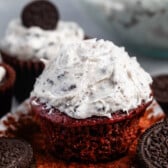 oreo frosting on top of a chocolate cupcakes next to oreos.