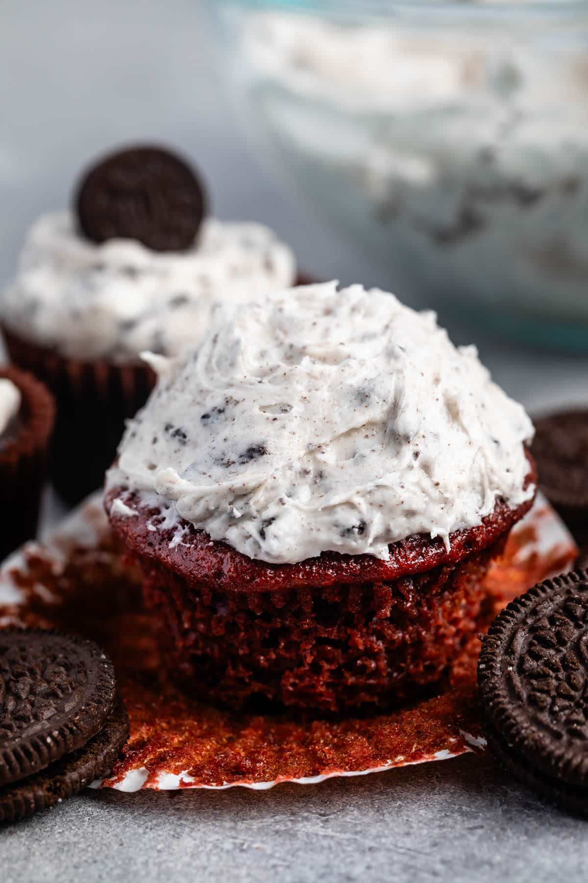 oreo frosting on top of a chocolate cupcakes next to oreos.