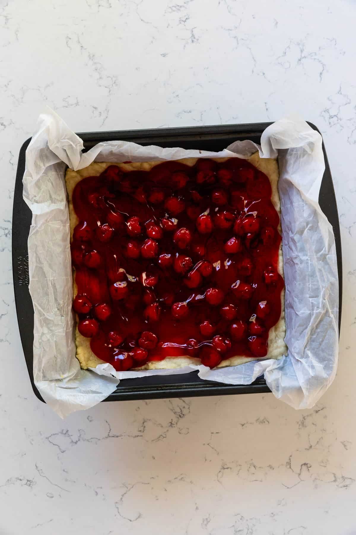 process shot of cherry pie bars being made.