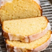 sliced lemon bread with a glaze on top on a drying rack.