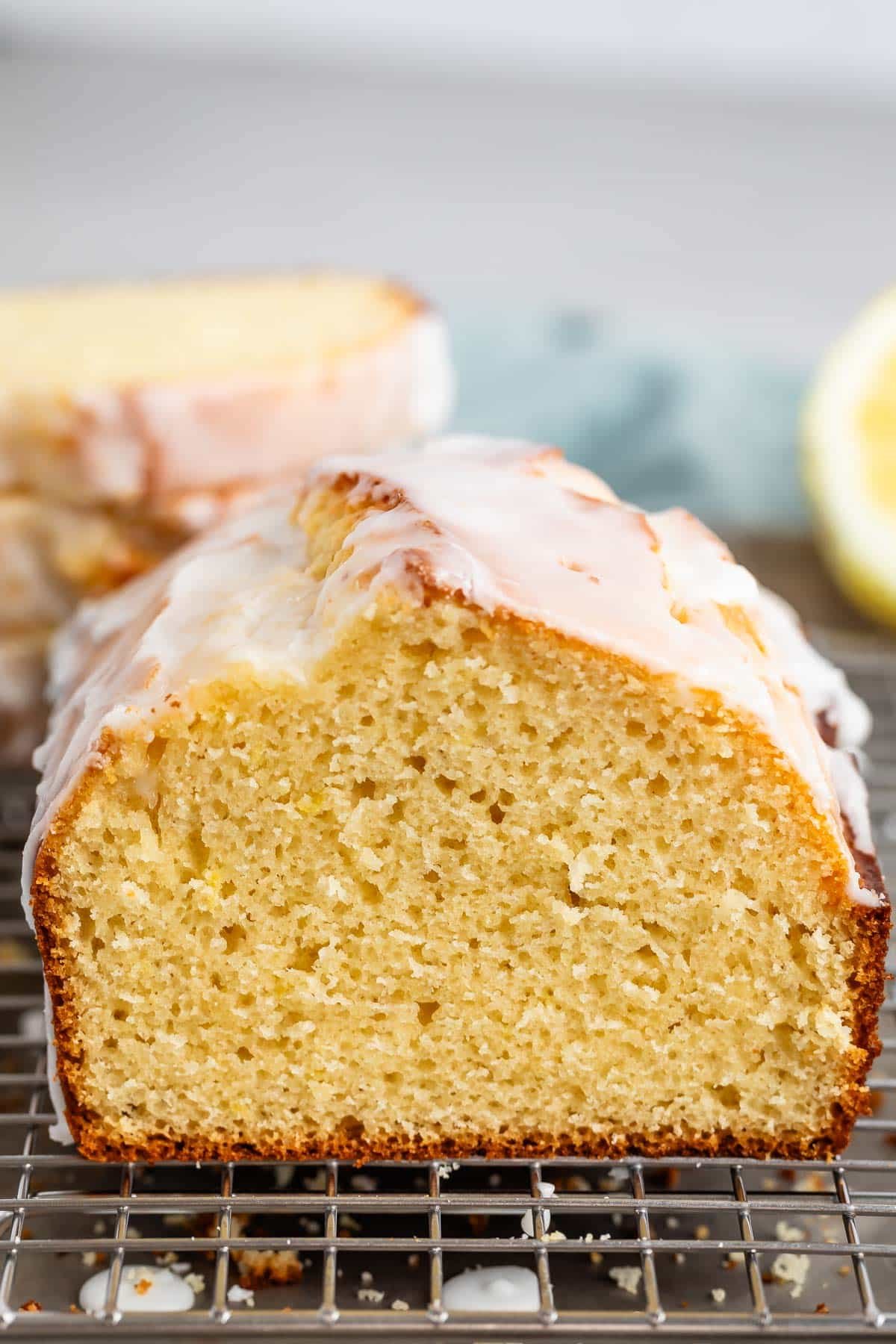 sliced lemon bread with a glaze on top on a drying rack.