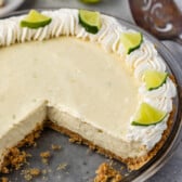 key lime pie with whipped cream and sliced limes on top.