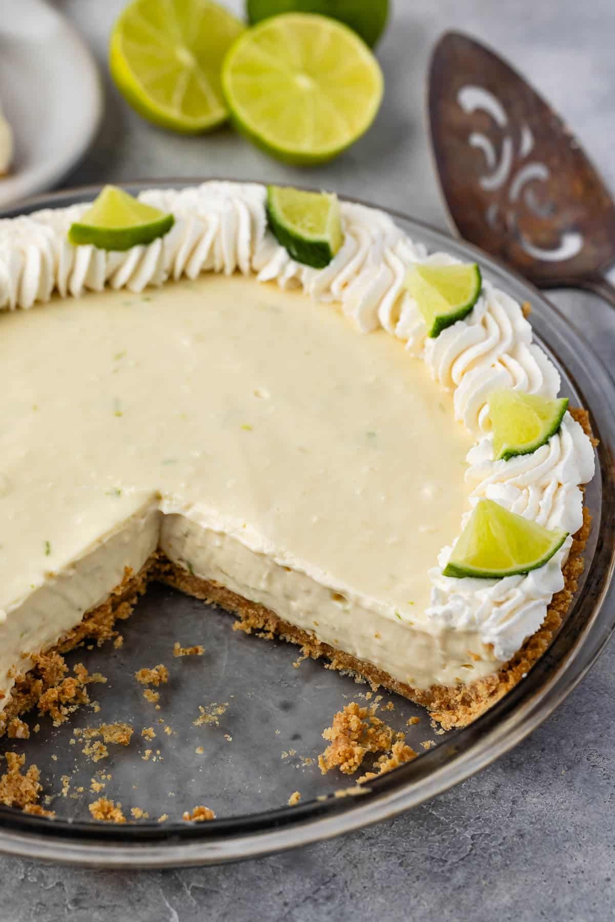 key lime pie with whipped cream and sliced limes on top.