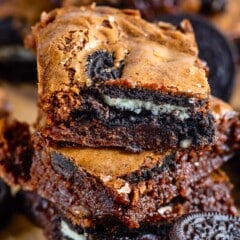 stacked oreo brownies on a cutting board.