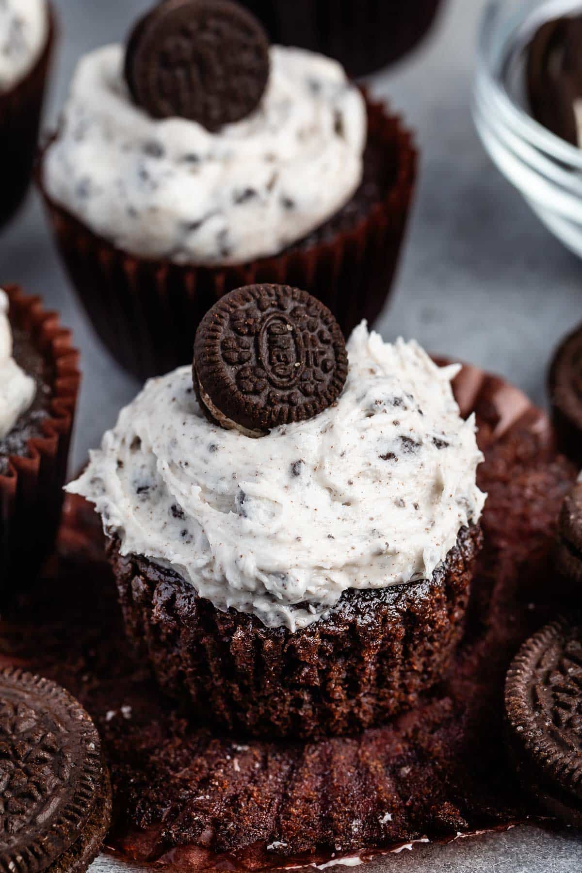 chocolate cupcake with white Oreo frosting and a mini Oreo on top.