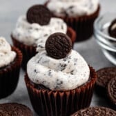chocolate cupcake with white Oreo frosting and a mini Oreo on top.
