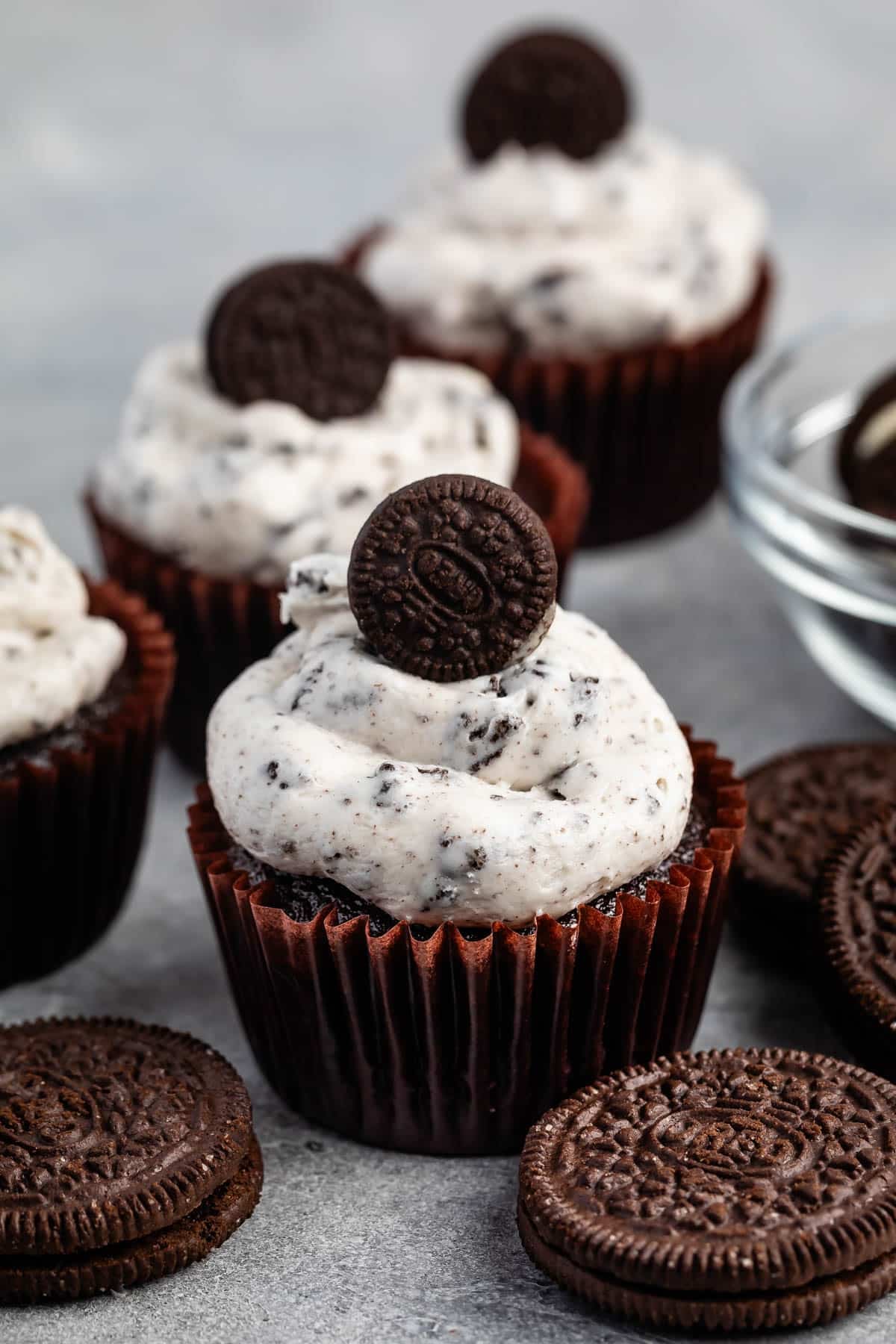 chocolate cupcake with white Oreo frosting and a mini Oreo on top.