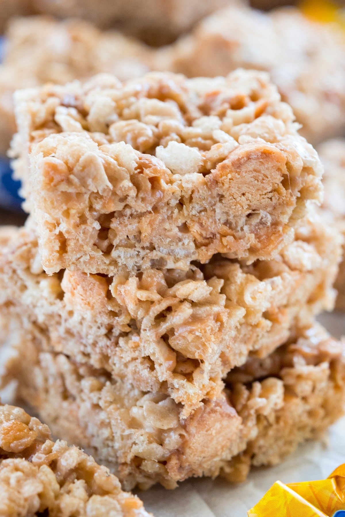 stacked Rice Krispie treats with butterfingers spread around.