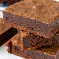 stacked brownies on a white counter.