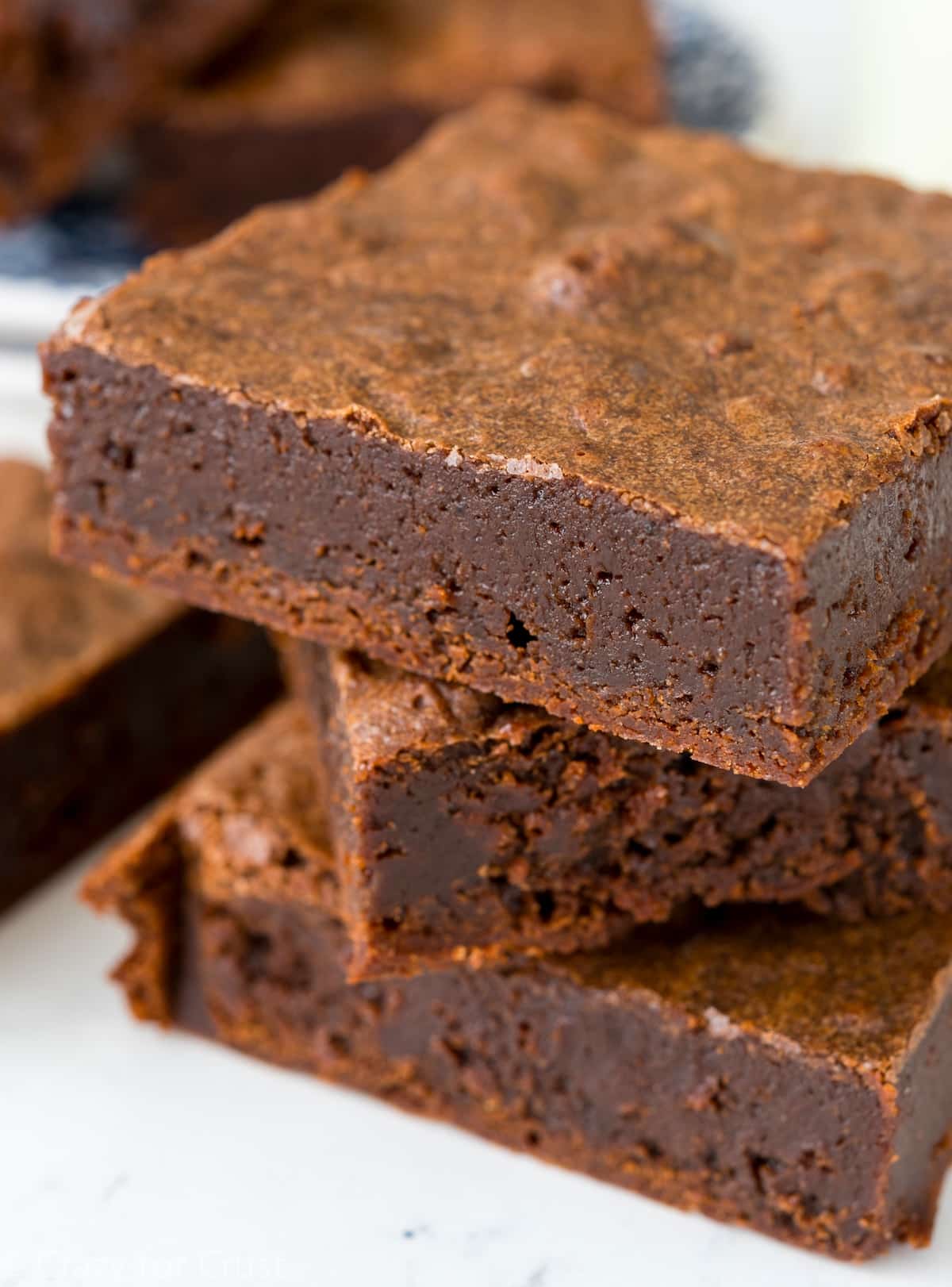 stacked brownies on a white counter.