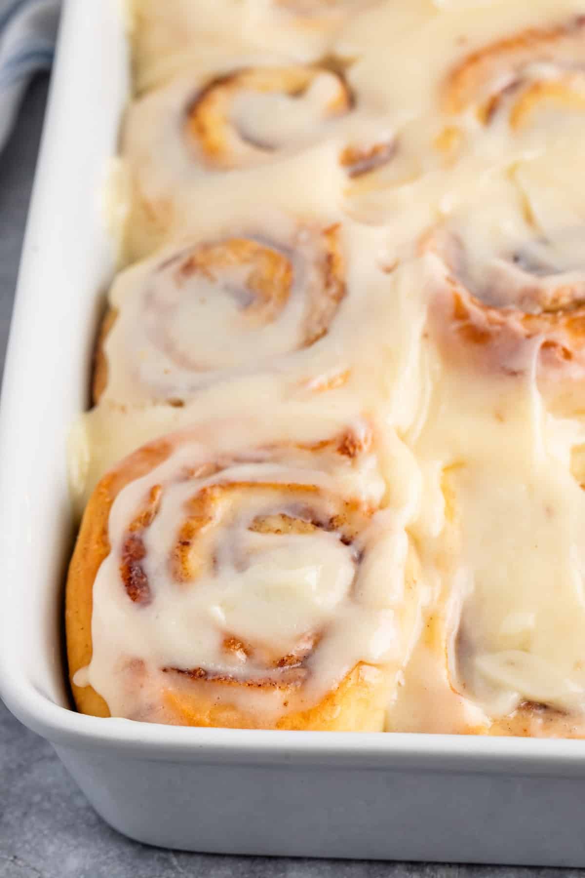 cinnamon rolls sitting in a glass white pan.