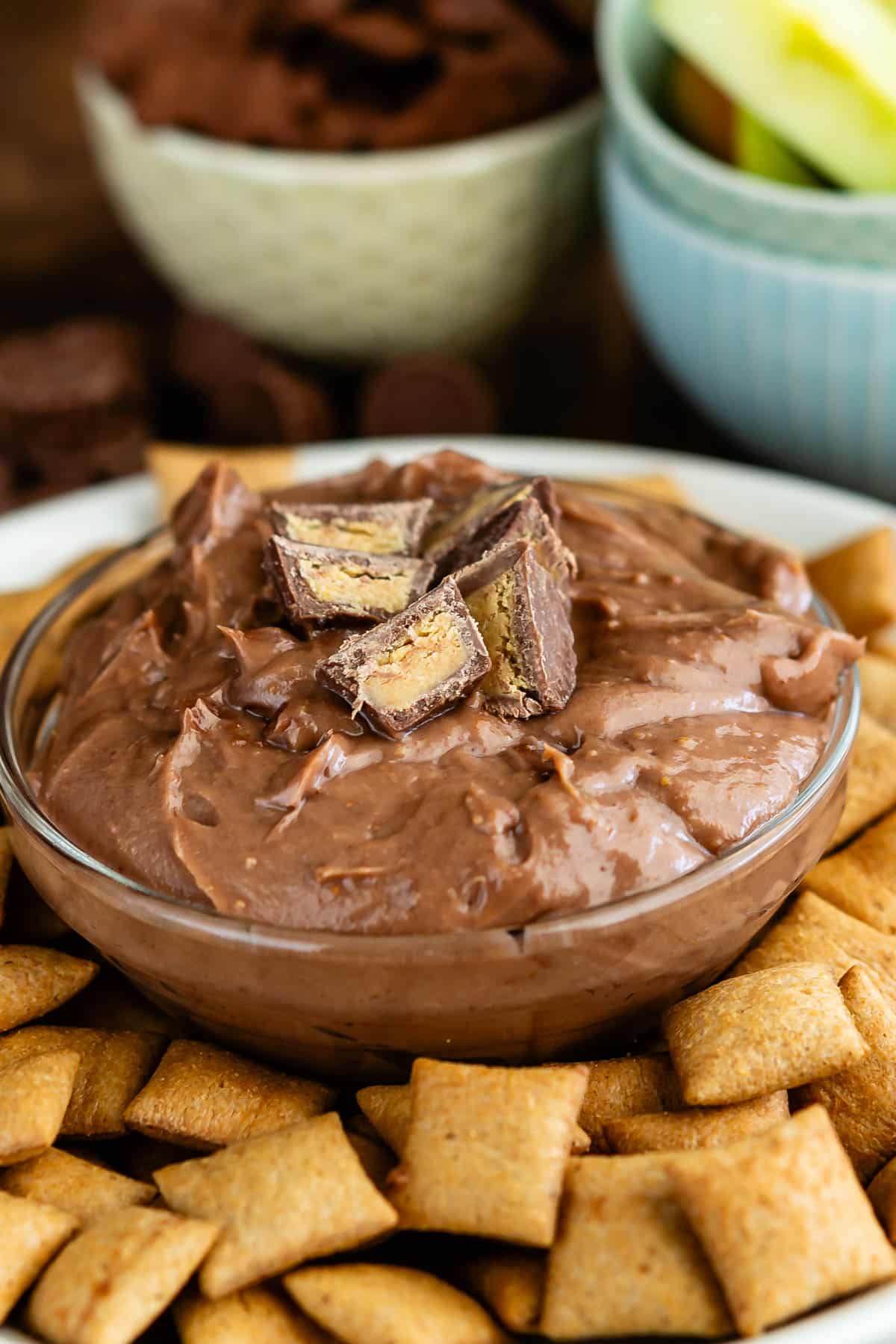 chocolate dip in a clear bowl surrounded by crackers.