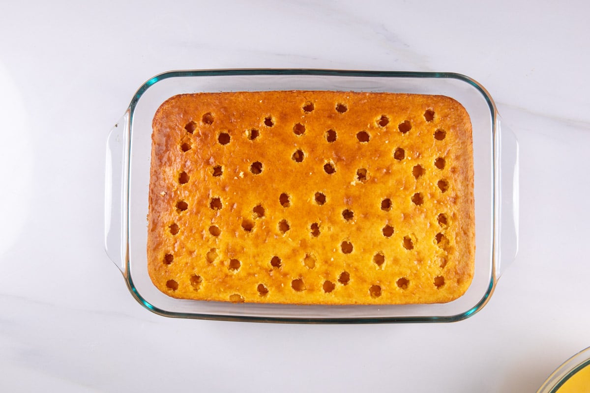 process shot of cereal milk poke cake being made.