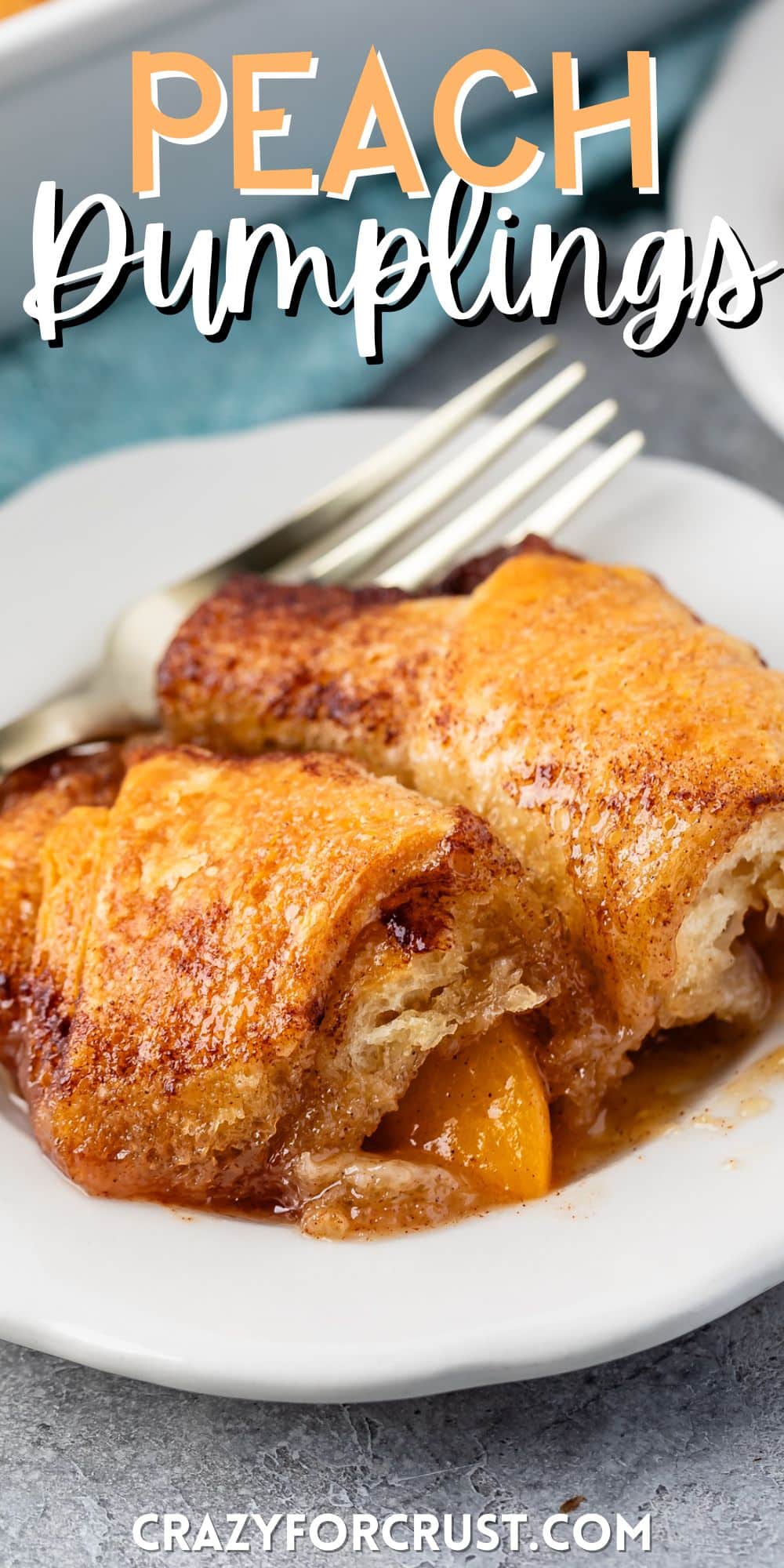 two crescent roll dumplings on a white plate next to a fork with words on the image.