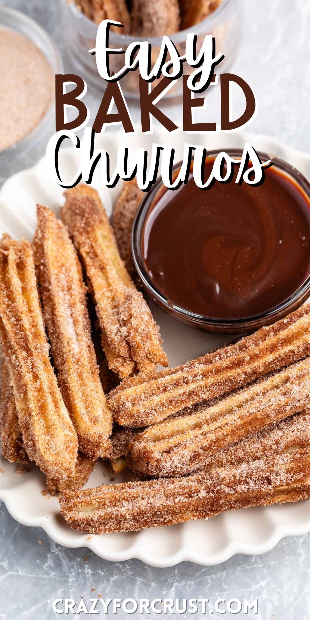churros covered in cinnamon sugar on a white plate next to chocolate with words on the image.