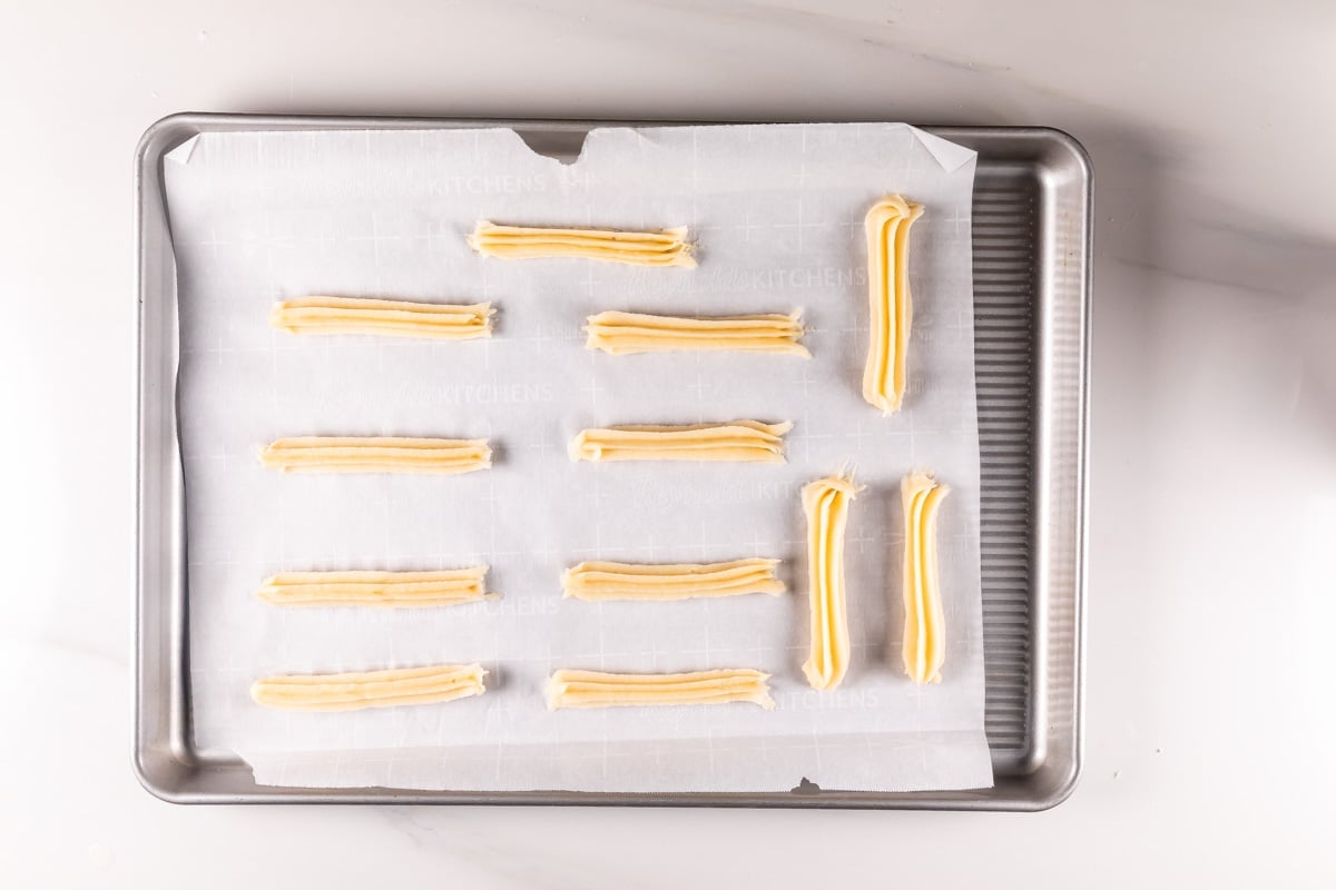 process shot of baked churros being made.