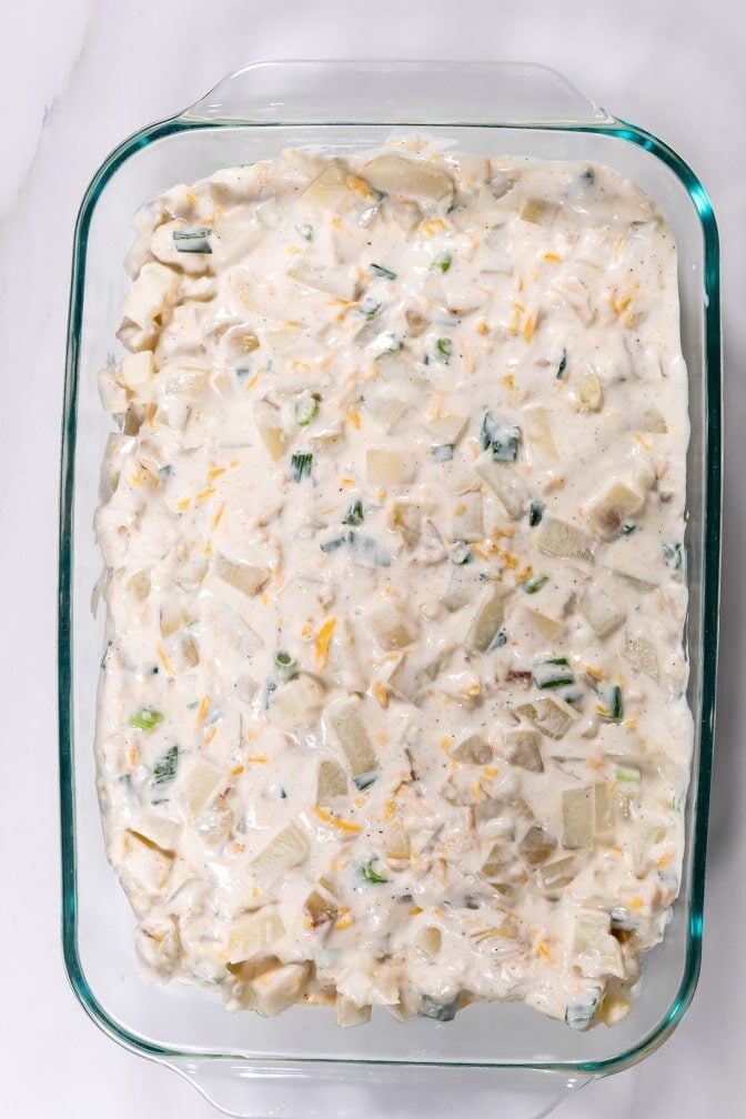 process shot of cheesy potato casserole being made.