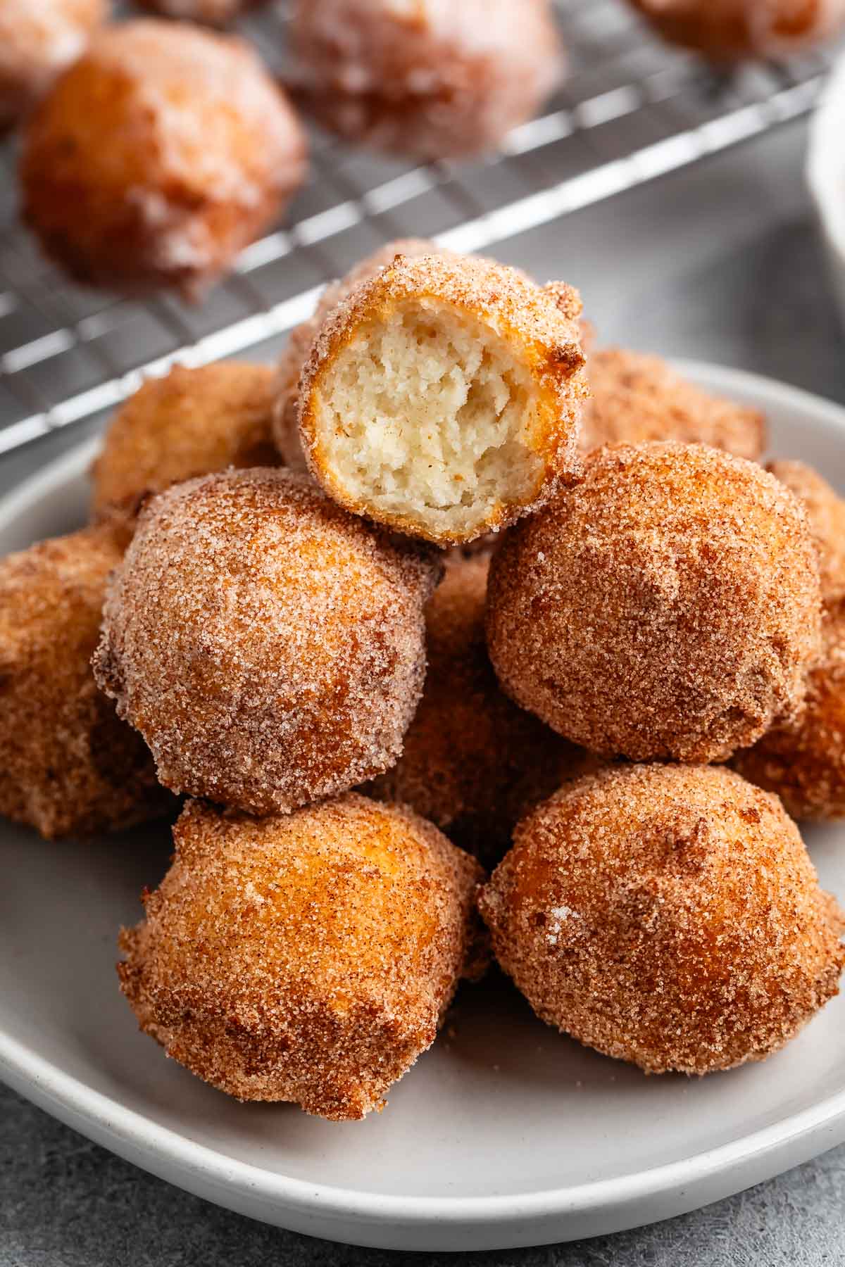 stacked donut holes on a grey plate.