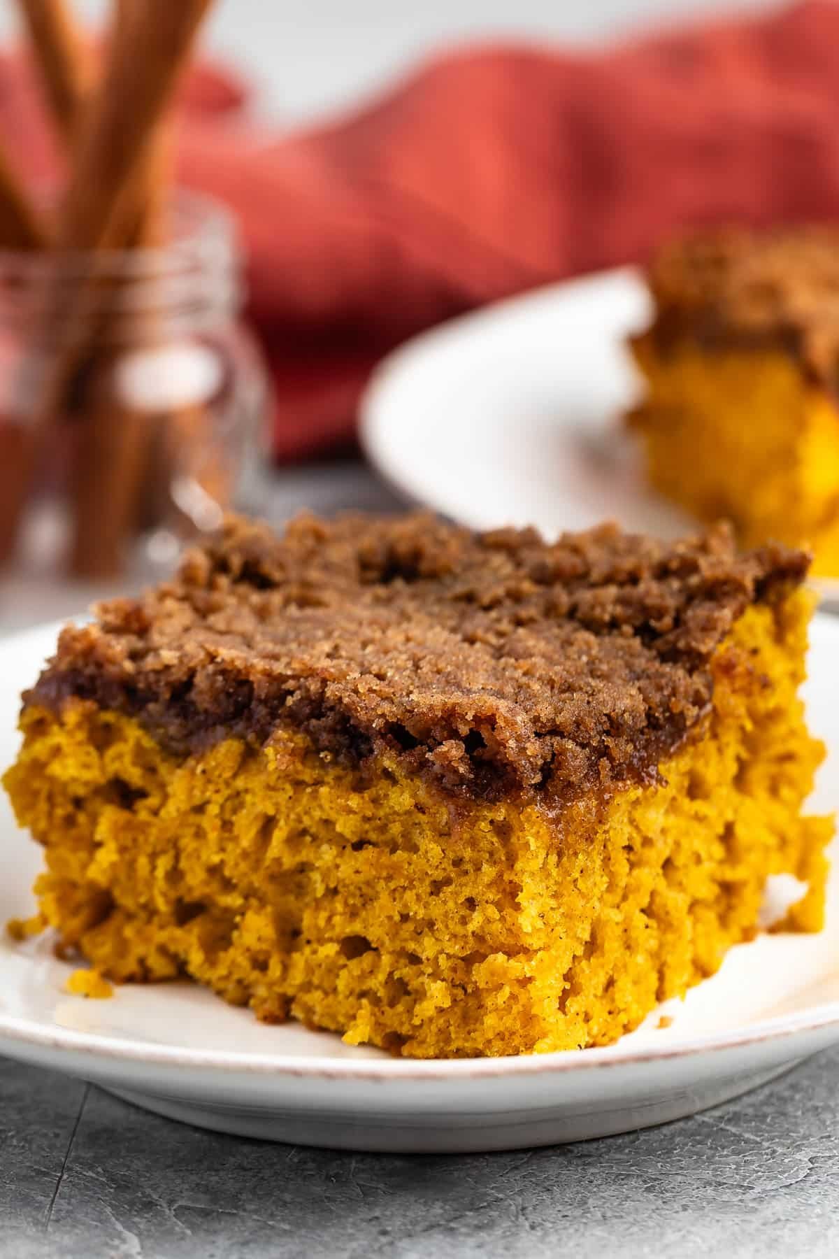 square slice of pumpkin coffee cake on a white plate.